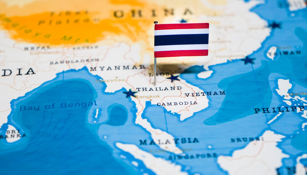 Flag pinned into map of Asia showing Thailand.